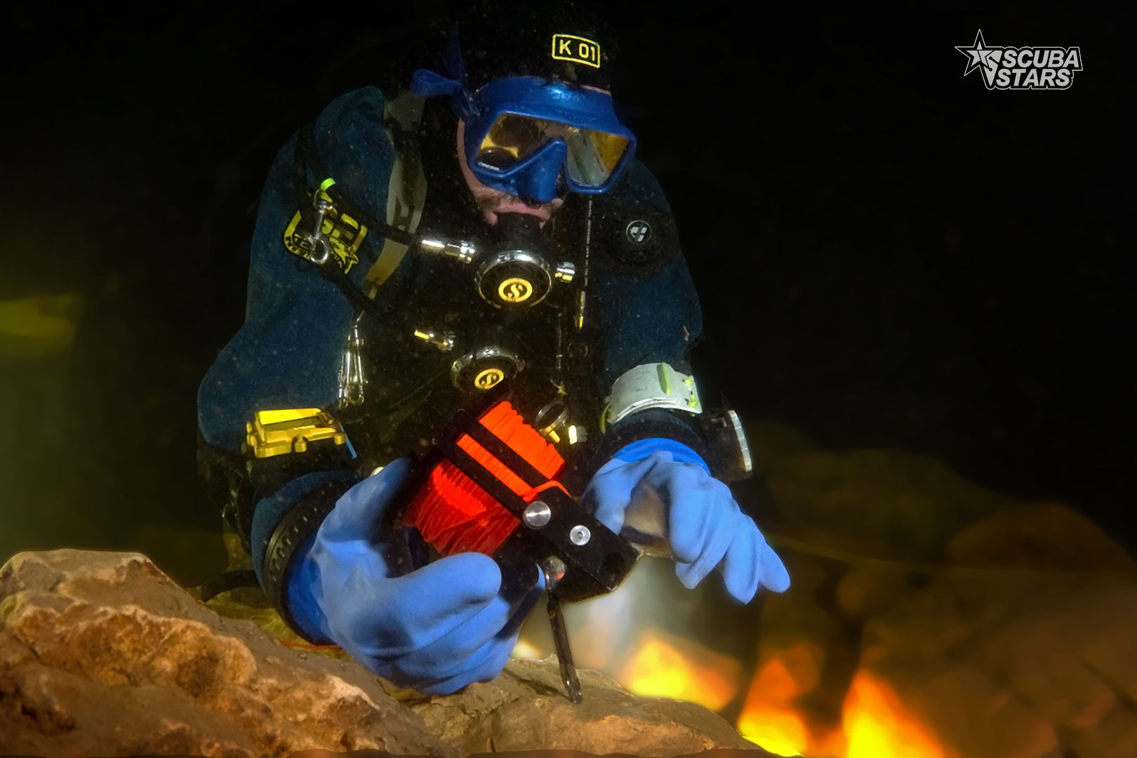 un plongeur qui installe une ligne dans un grotte a l'aide d'un dévidoir